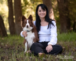 brown-and-white-bordercollie-sitting-with-pretty-woman-under-trees
