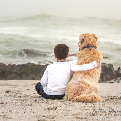 boy-and-dog-sitting-together-on-the-beach