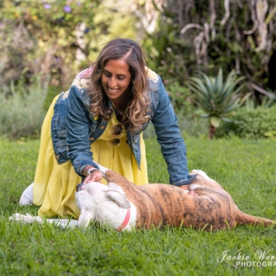 woman-playing-on-the-grass-with-brindle-and-white-pitbull